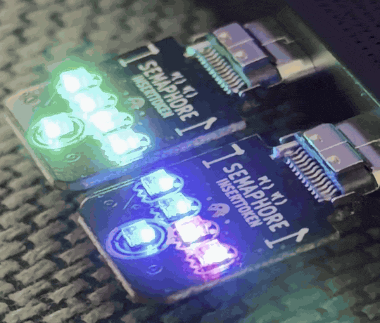 Animated loop of two Semaphore boards plugged into a laptop, each lighting its LEDs a different color and changing independently